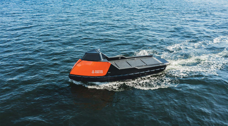 Side-aerial view of the orange-colored Mariner X USV in the open ocean.