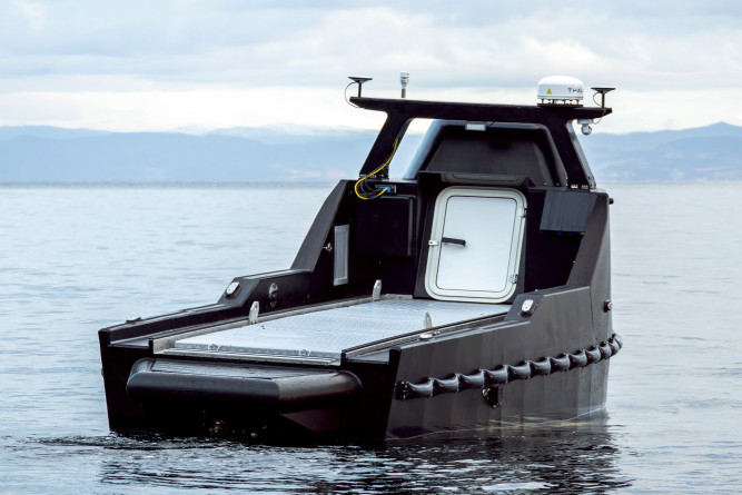 Rear view of the Mariner X USV, featuring the back deck with an access door to the engine and a customizable railing system for various payloads.