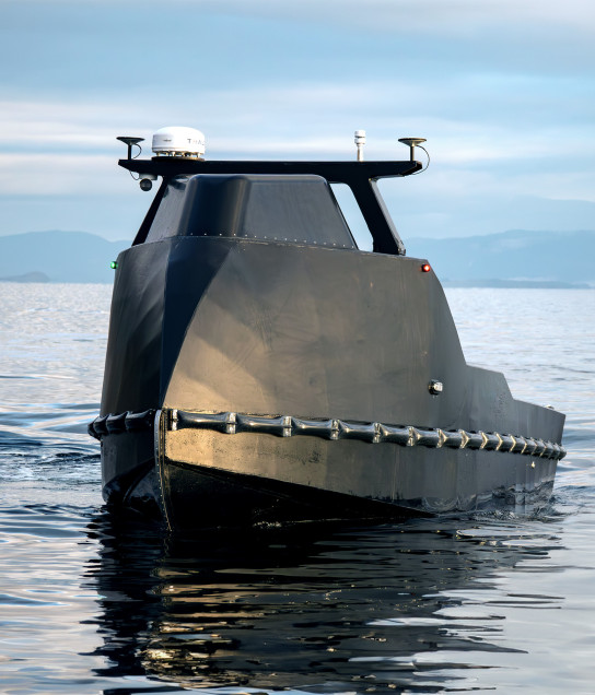 Front view of a black Mariner X USV approaching in the open ocean.